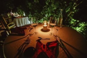 Intimate evening outdoor dining with candlelight and wine glasses.