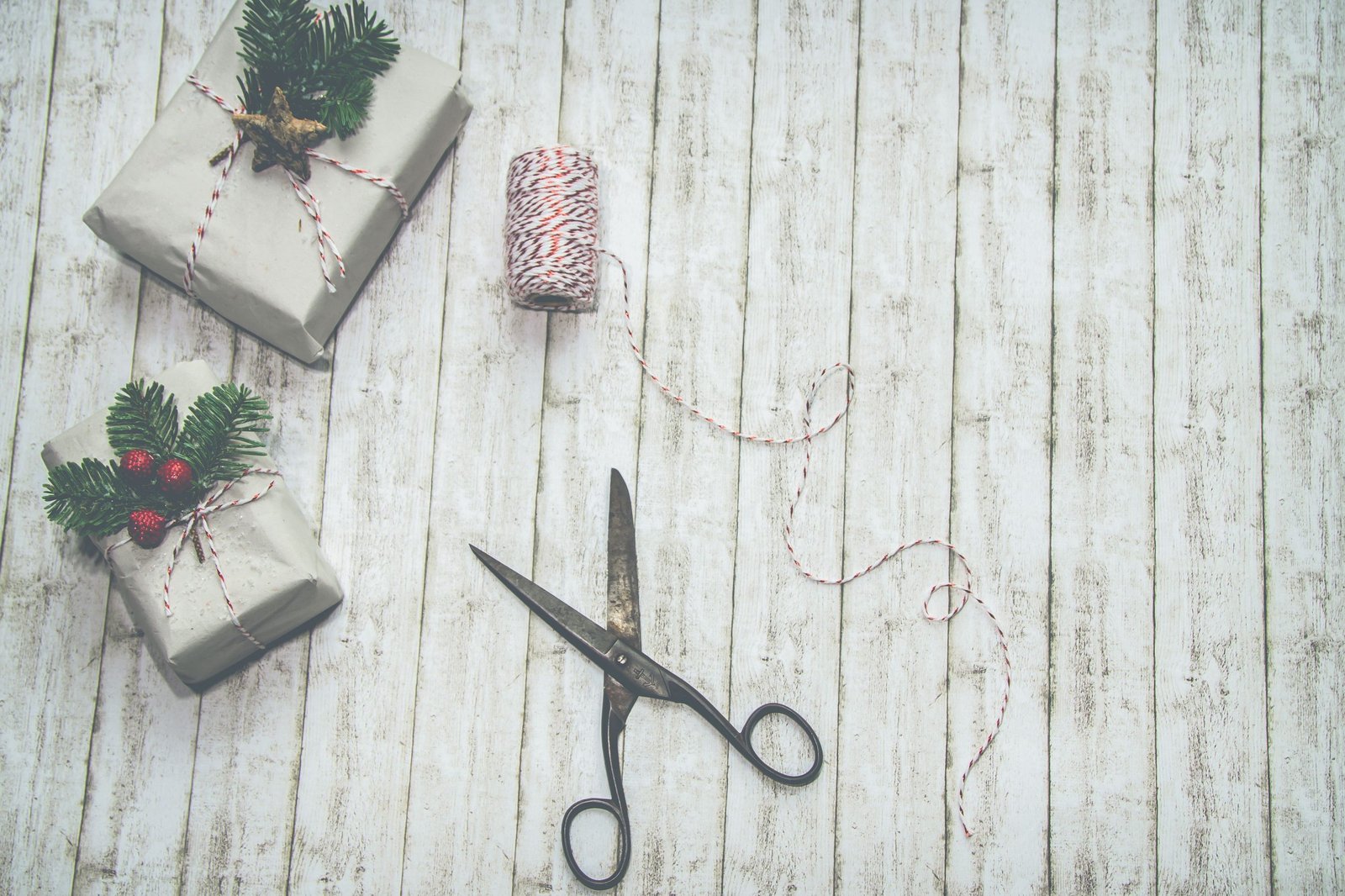 Festive Christmas presents with rustic wrapping and decorations on a wooden backdrop.
