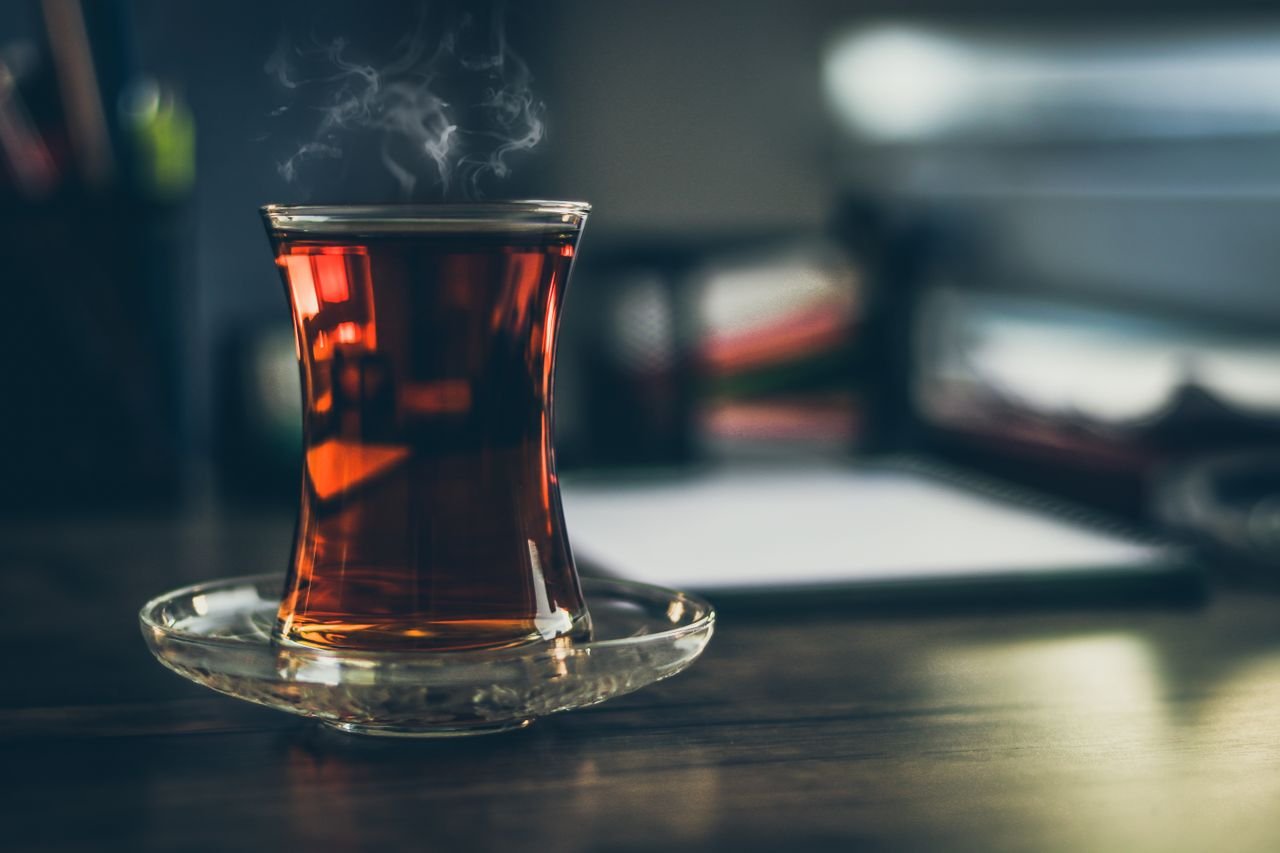 How we work Close-up of steaming Turkish tea in a traditional glass, creating a cozy and inviting atmosphere.